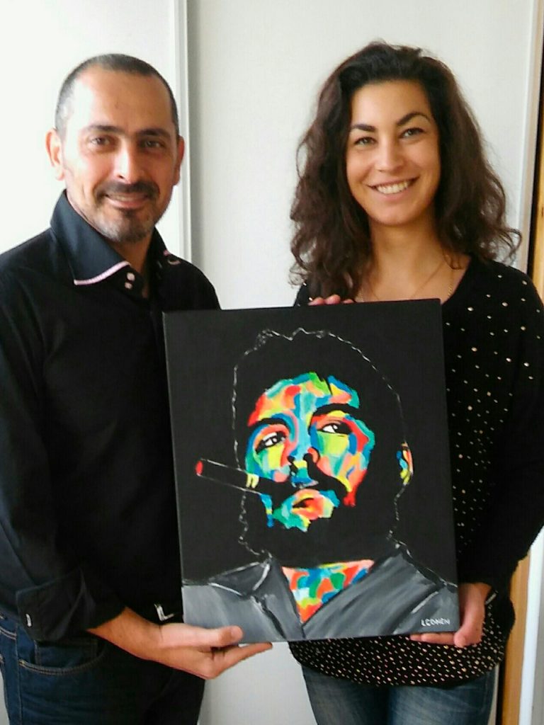 Lionel Cohen et une jeune femme posant avec un portrait