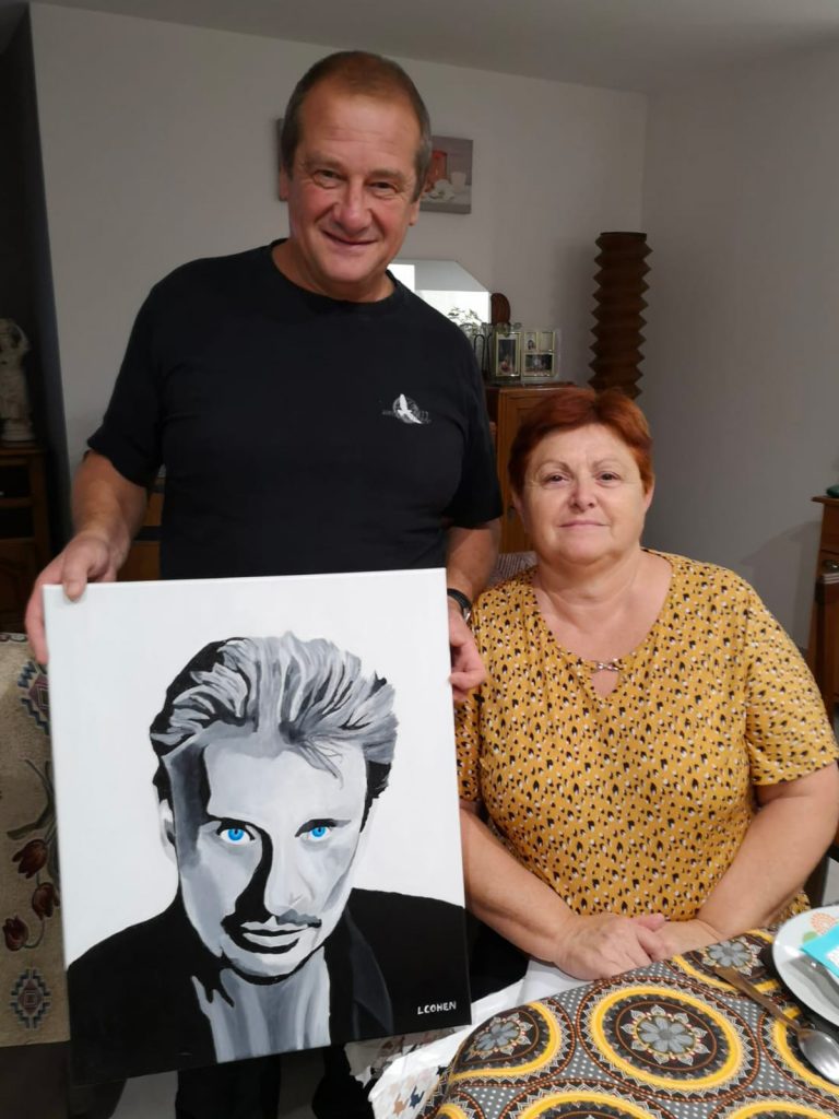 Couple posant avec le portrait de Johnny Hallyday