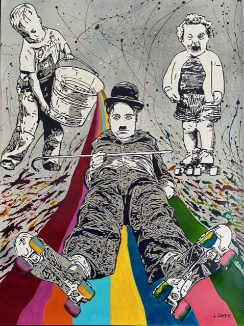 Charlie Chaplin au sol avec des rollers, un enfant renverse un sceau de peinture multi couleur et un autre enfant sur des rollers rie